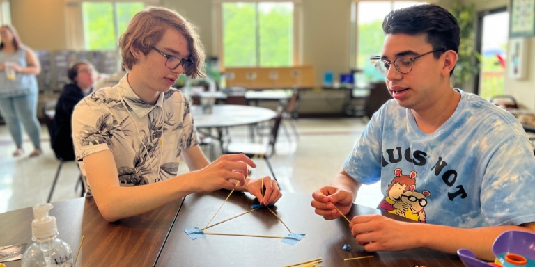 Two male students work on a project. 
