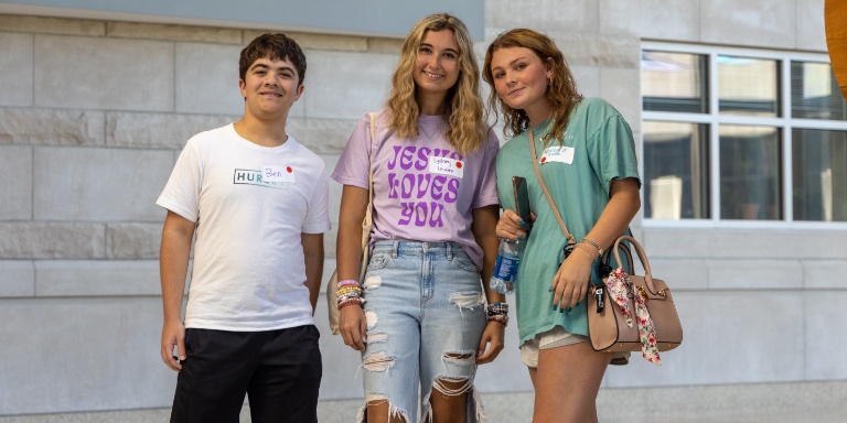A group of three students pose in Hunt Hall. 