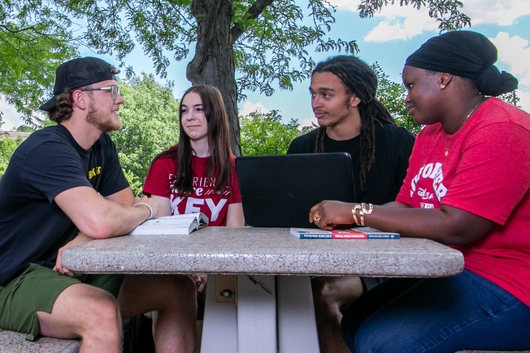 A group of students chat outdoors. 