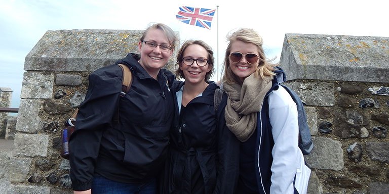 Three girls standing in front of a British Flag