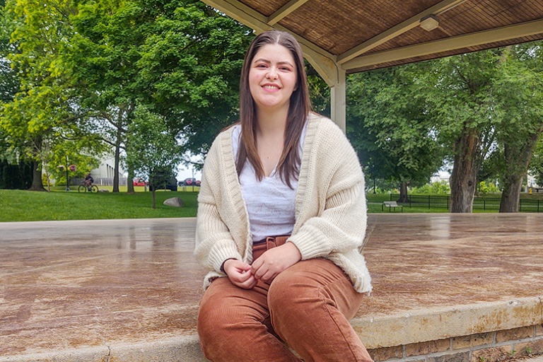 student sitting on pavilion stage outside