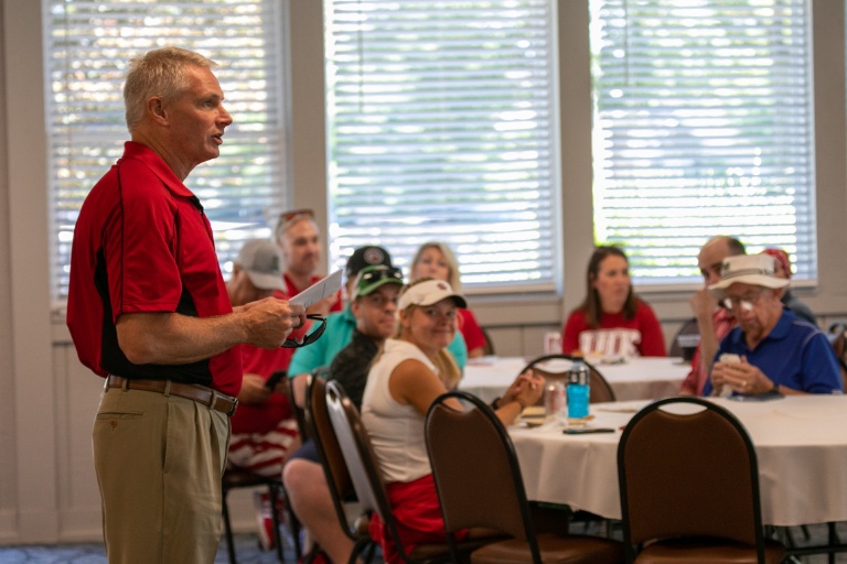 Chancellor speaking at a golf event.