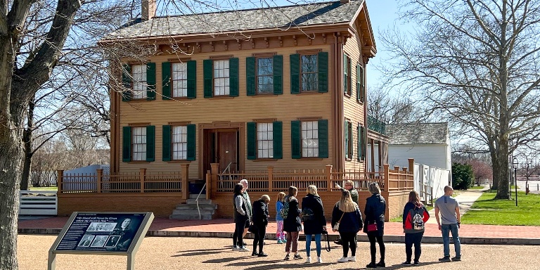 Students standing in front of an historical home.