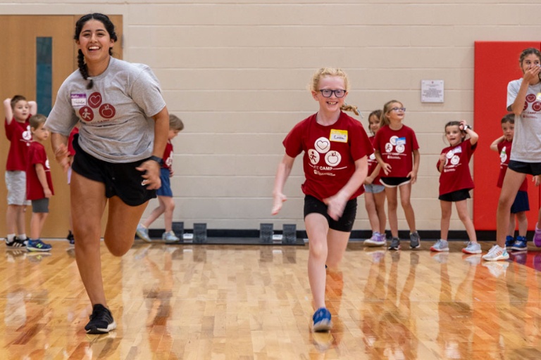 IUK students running with children at FIT camp.